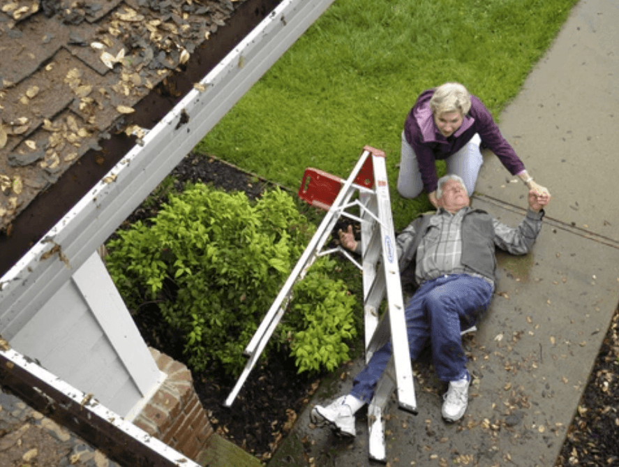 Older man climbing ladder with woman assisting from above in residential yard