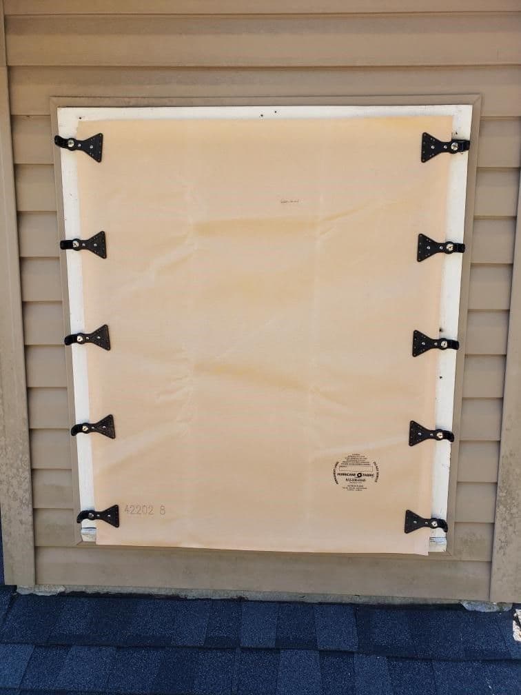 Back of a framed canvas with white border and black bow-tie fasteners securing the canvas to the frame