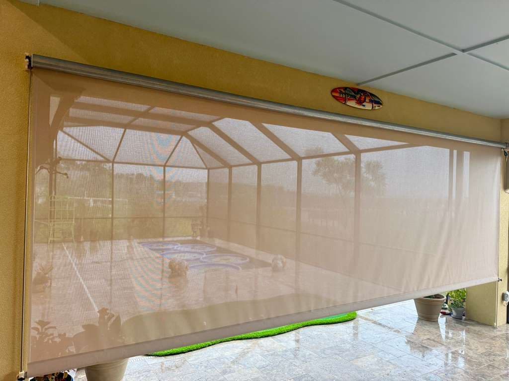 Retractable tan mesh screen door covering a patio with pool and lounge chairs visible through the screen